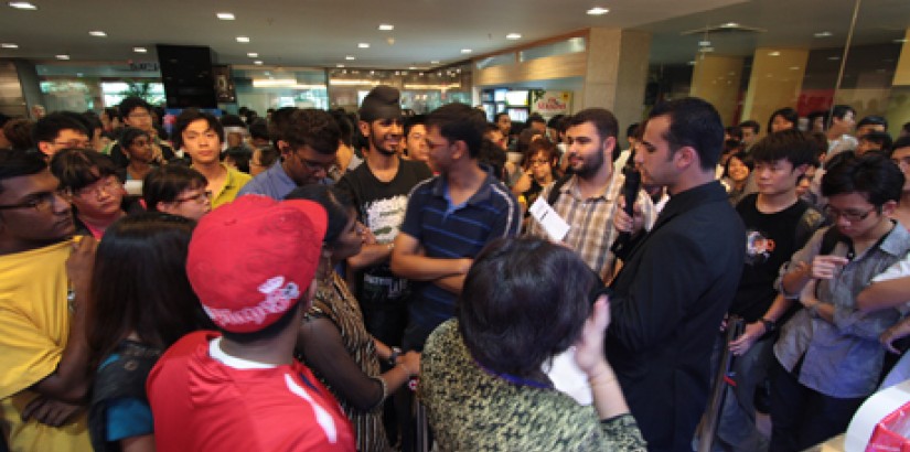 Students and staff members wait anxiously for their name to be called out during the lucky draw announcement.