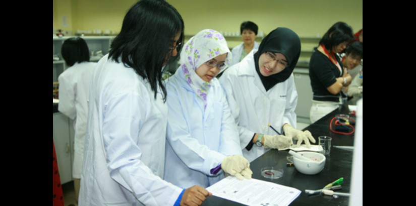  Team 4; Nadia Shafina bt. Razali and Nuramalina bt. Samar with a lab technician, penning down their results from the experiment conducted during the workshop