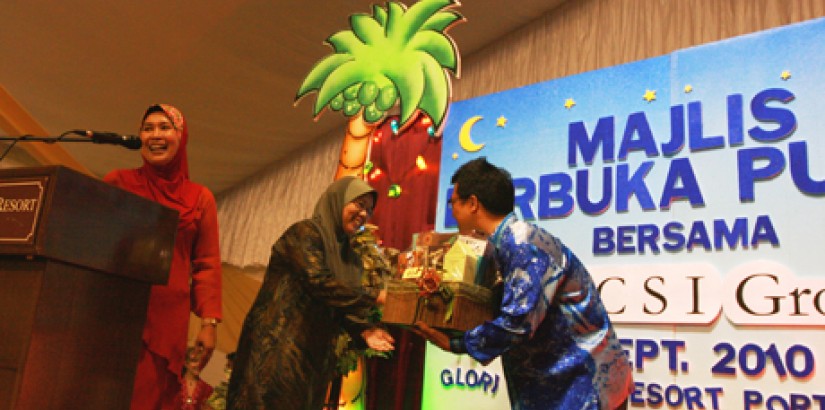Dato’ Peter presents Puan Hajah, wife of District Officer Tuan Haji Ab Khalid, with a Ramadan hamper after her name was called for the drawing. More than 60 hampers were given away to guests throughout the evening.