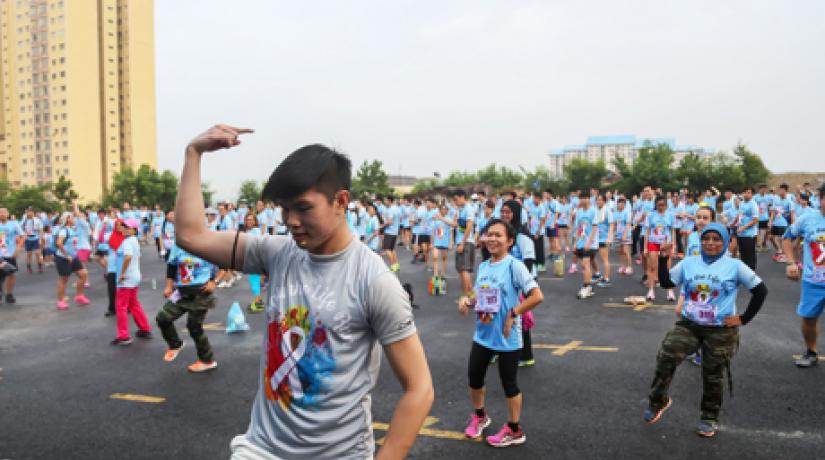 A student facilitator from UCSI University leads the runners in an aerobics warm-up session before the run commenced.