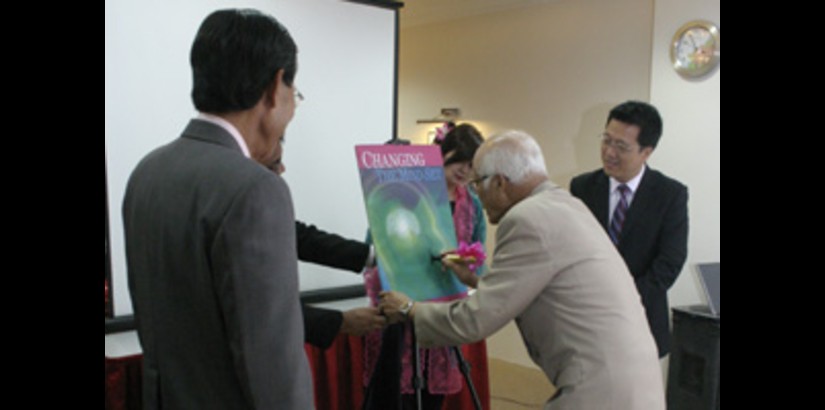 Tan Sri Chancellor signing the mock-up of the book during the launch