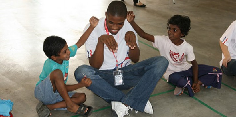 A UCSI University student volunteer plays games with children at the Desa Amal Jireh orphanage during the "Light Up Lives" charity event.