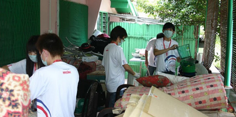 Students cleaning up the garage at one of the old folks homes during the “Light Up Lives” charity programme.