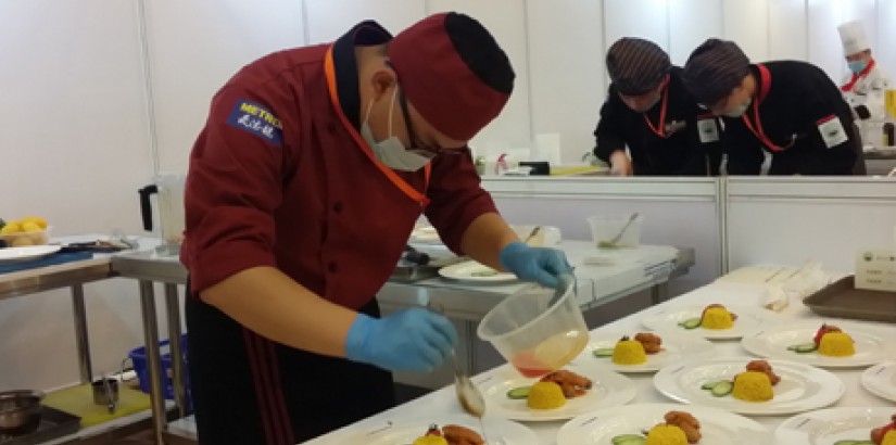  [THE WINNING DISH]: Lee Wei Ming preparing the Ayam Masak Merah with Nasi Kunyit.
