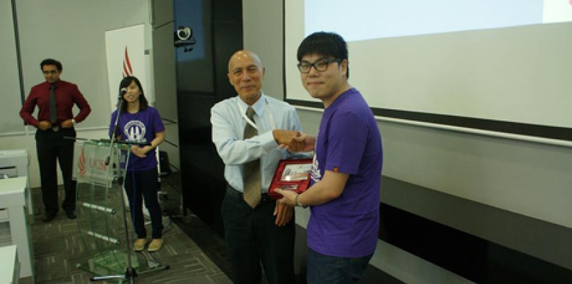  APPRECIATION: A representative from The Hong Kong Polytechnic University in the midst of presenting a token of appreciation to Faculty of Business & Information Science deputy dean Professor Leo Fredericks.