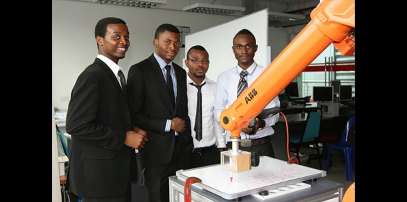 Some foreign final year engineering students with their machine configure to write letters and numbers onto a board showcased at the Ehxibition