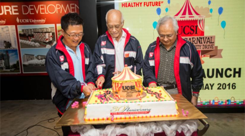 HAPPY OCCASION: (left-right) Dato’ Peter Ng, Tan Sri Arshad and Senior Prof Dato’ Dr Khalid cutting the cake during UCSI’s Family Carnival and Charity Drive.