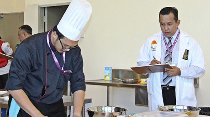 Christopher Wan Sageng (left) working on his dish during the Penang International Halal Chef Challenge 2015 (PIHCC)