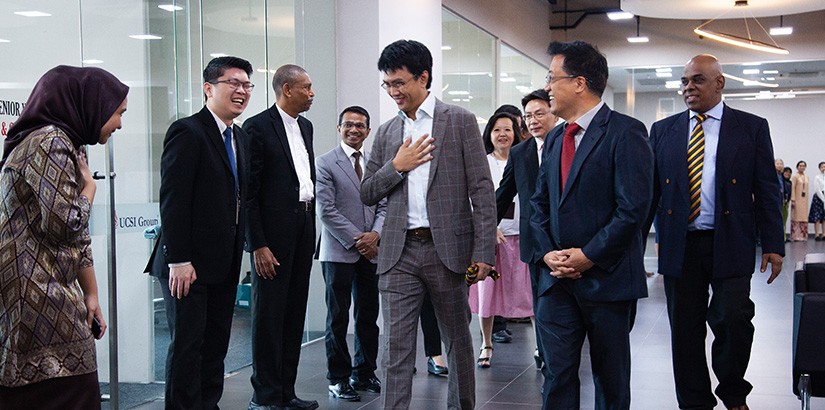 Executive Director of ICAN, Tunku Dato Seri Zain Al-Abidin ibni Tuanku Muhriz accompanied by UCSI Group CEO and Founder Dato Peter Ng greeting one of UCSI staff during the signing ceremony.
