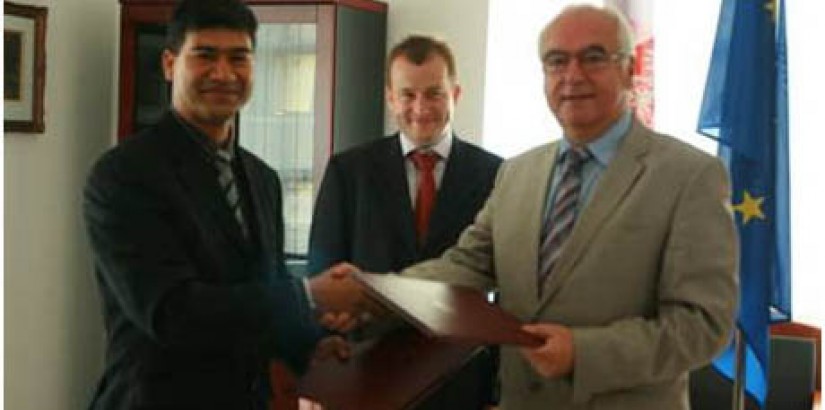 Assoc. Prof. Dr. Lachman Tarachand and Professor Witold Bielecki sealing the agreement with a handshake while His Excellency Prof Adam W. Jelonek looks on.