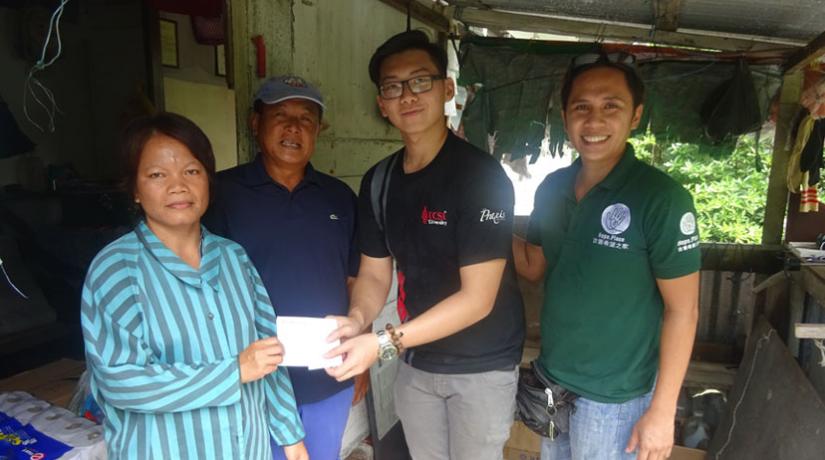 Hope Place member, Peter and one of the organising committee member handing over cash donations to Ho’s family who live with poor housing facilities near a swamp area.