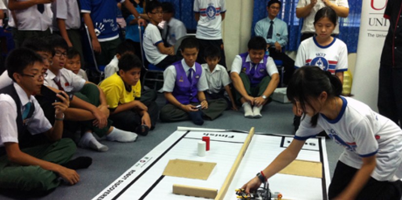 A student testing her creation as the other participants look on.