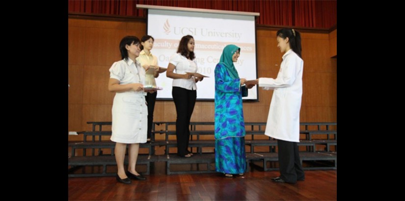  Pn. Adiba Haq (second from right), gives a copy of the Pharmacy Oath to a student, observed by Assoc. Prof. Dr. Yeong Siew Wei, Dean of the Faculty of Pharmaceutical Sciences