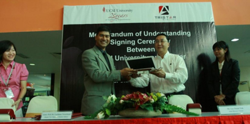 Assoc. Prof. Dr Lachman Tarachand receiving one of the Macbooks from Mr Lee Thuan Teik.