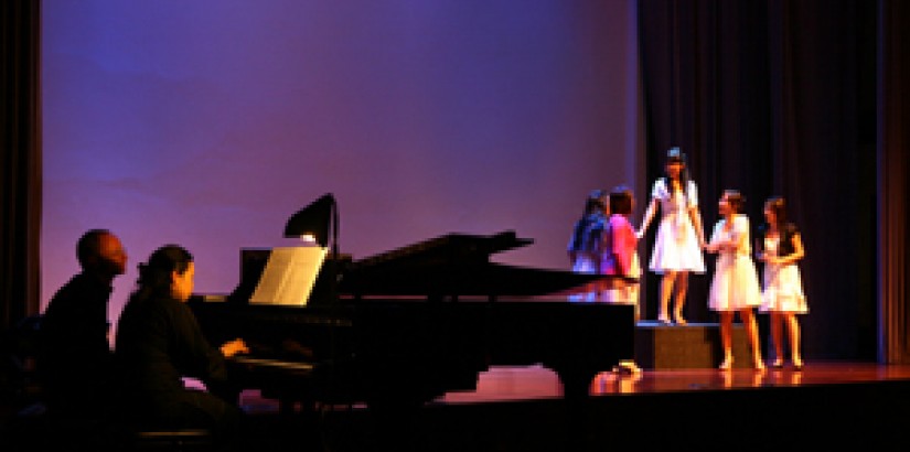 Student sopranos in a scene called "Saria Possible" (aria from I'Elisir d'amore) where the women in the village are gossiping about a the local eligible bachelor who has just inherited a large fortune from his deceased uncle. Accompanying them on the pian