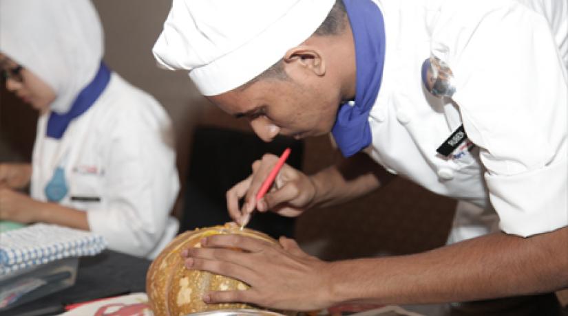  EDIBLE ART: Student Kantharuben A/L Munis from Politeknik Merlimau Malacca carving a pumpkin during the MyCenTHE Skills Challenge 2015 that was held concurrently with the symposium.