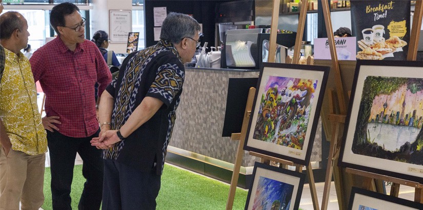 Dato’ Mohd Yusof Ahmad examining one of the participants artwork at the exhibition for mySENI 2019 Painting Competition