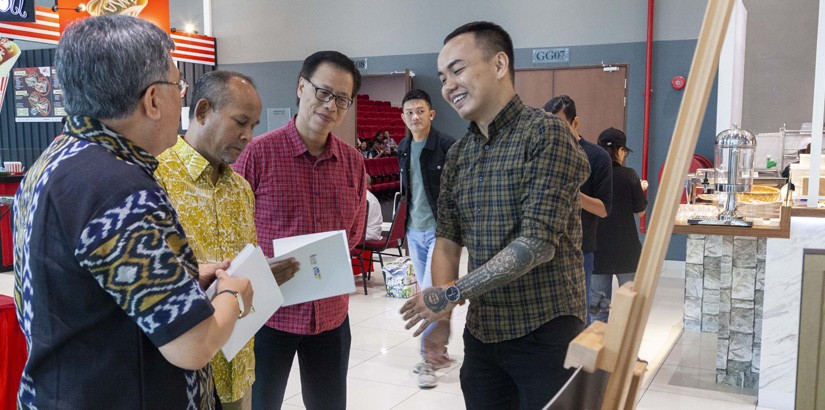 Chairperson of mySENI Painting Competition, Lucas Lim Boon Leong explaining to Dato’ Mohd Yusof Ahmad regarding the event with the presence of UCSI Group Corporate Affairs vice-president, Leong Sat Sing.