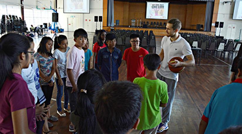  FUN TIME: Student Affairs & Alumni division head (Sports and Fitness Department) Vitalii Goncharenko engaging children in a basketball game.