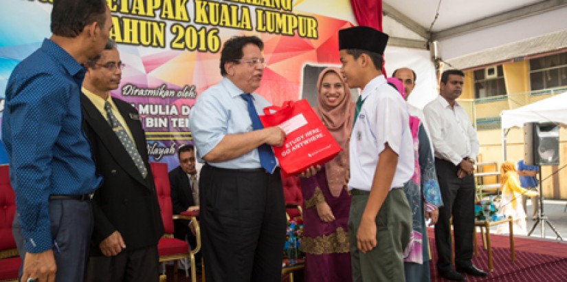 (third from left) Tengku Adnan handing one of the 53 free spectacles to a student of SMK Tinggi Setapak as Asst Prof Dr Lili, head of UCSI’s School of Optometry, looks on.