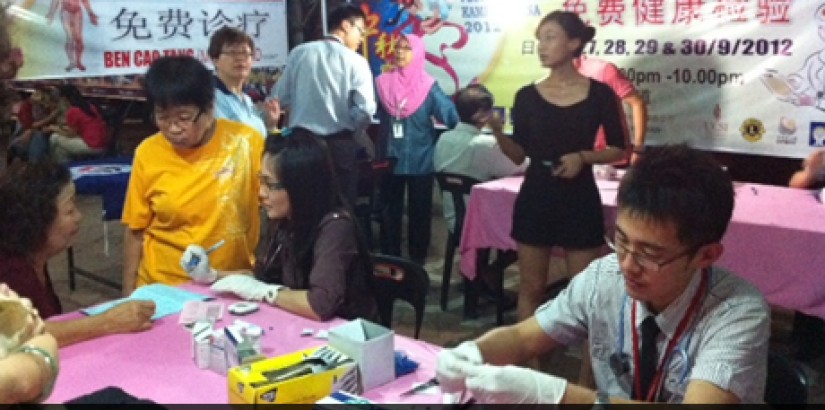 Busy helping - UCSI University's medical students together with the local Lion's Club provides the local community with free health screen and advice every evening during Pesta Tanglung 2012.