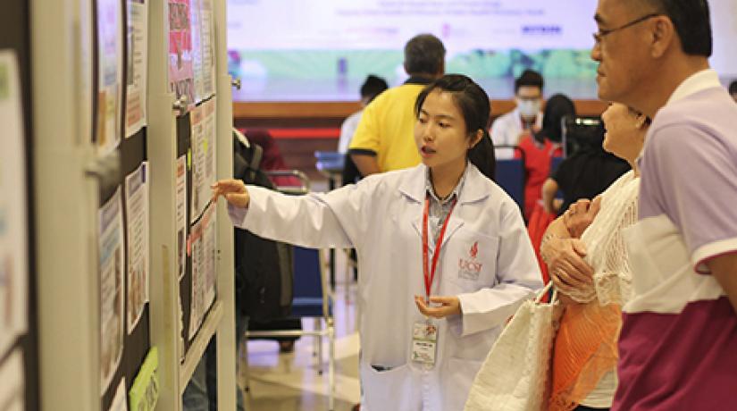  AN EARLY START: A UCSI pharmacy student explaining healthcare-related information to two visitors of the Annual Public Health Campaign.