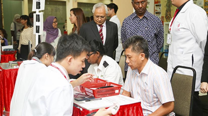 FUTURE PHARMACISTS: UCSI pharmacy students explaining the results of a body fat test to a member of the public as Senior Prof Dato’ Dr Khalid (left, standing) and Dr Balachandran, Selangor Health Department Director (middle) watches on.