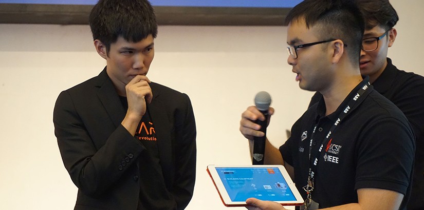 Harry (right) president of IEEE HKN Mu Alpha Chapter asking questions about SOURCE to Guan (left), technology development engineer from Plus Solar Systems Sdn Bhd