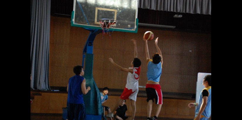  QUICK MOVES: A Pre-U student goes all-out to net a slam dunk while another student tries to block his path during a competitive basketball game. 