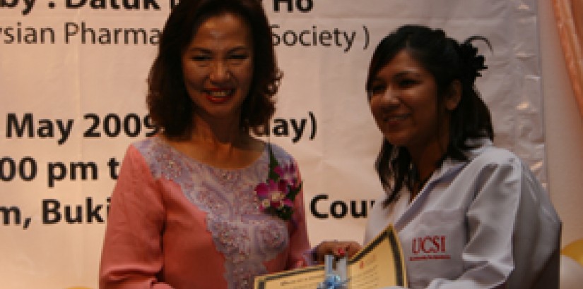 Datuk Nancy Ho giving a copy of the oath to one of the students