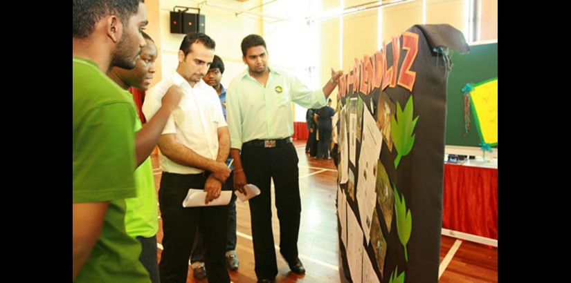 A UCSI University International student explaining his groups project to one of the judges during the 'University Life' final showcase