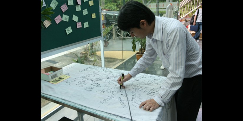  Neo Chin Sin, a member of the UCSI Group staff, shows his support by signing his name to the library’s signature collection centre