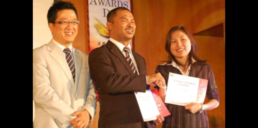 Lim Yin Bao receiving her sports scholarship certificate from the Deputy Minister of Higher Education