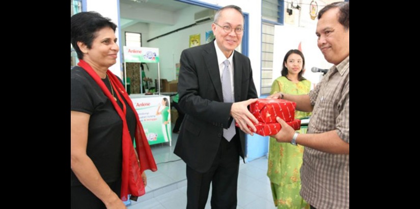 Dr. Robert Bong hands over a token of appreciation to En. Mohamad Yunus (right) as Associate Professor Jeya Devi looks on