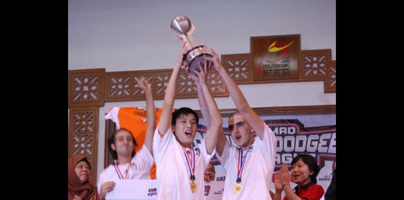 Team Captain Navid (right) and teammates hold up the trophy in jubilation