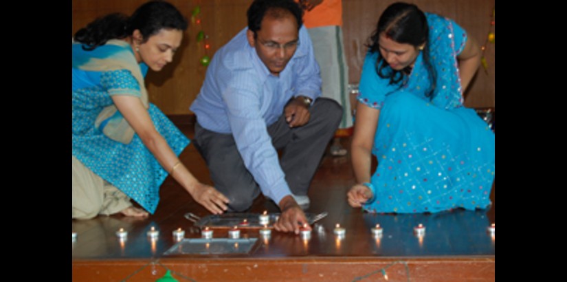 Hindu Staff members lighting candles during the climax of their sketch, which, recounted Lord Krishna's triumph over the demon Narakasura