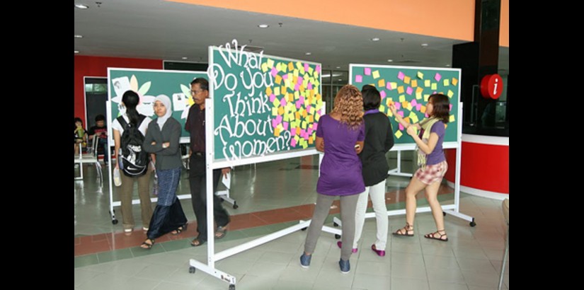  Students read about prominent women of the past 100 years at an exhibit during UCSI University's International Women's Week festivities.