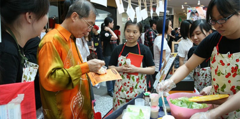 UCSI University Deputy Vice Chancellor Professor Dr. Lim Koon Ong samples food during the UCSI University WOW Food Fair 2011 at Empire Shopping Gallery in Subang Jaya