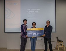 Dr Khairul (for right) handing out a cash prize mock cheque to a student for winning at the L’occitane Campaign Design Competition held in 2020. 