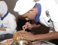  EDIBLE ART: Student Kantharuben A/L Munis from Politeknik Merlimau Malacca carving a pumpkin during the MyCenTHE Skills Challenge 2015 that was held concurrently with the symposium.