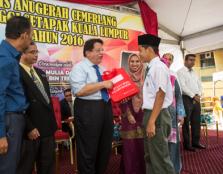 (third from left) Tengku Adnan handing one of the 53 free spectacles to a student of SMK Tinggi Setapak as Asst Prof Dr Lili, head of UCSI’s School of Optometry, looks on.