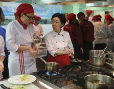 TOTAL FOCUS: Seoul University (Food Science and Nutrition department) Adjunct Professor Kim Kyung Mi (right) giving a student pointers on cooking bibimbap.